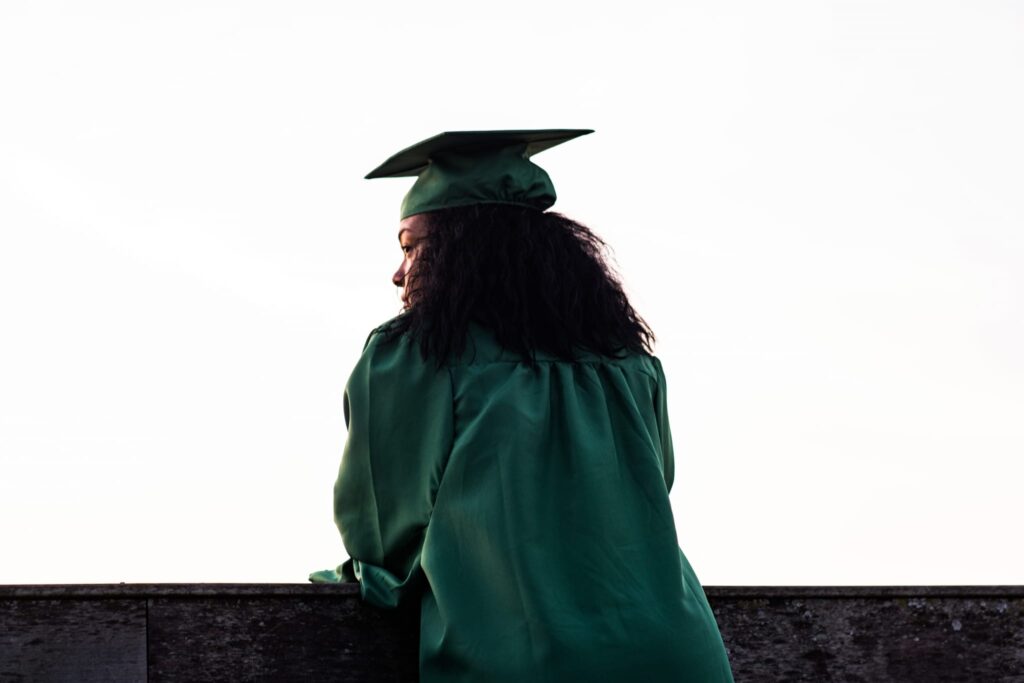 Grad student leans on the wall gazing away