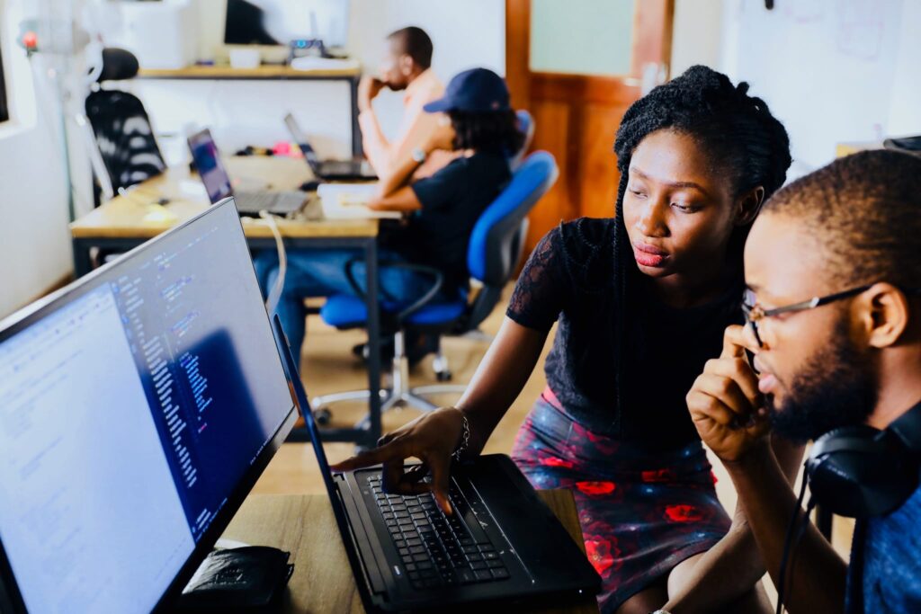 two people going over data on computer screens