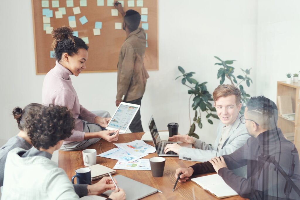 Six people in a meeting conversing over data