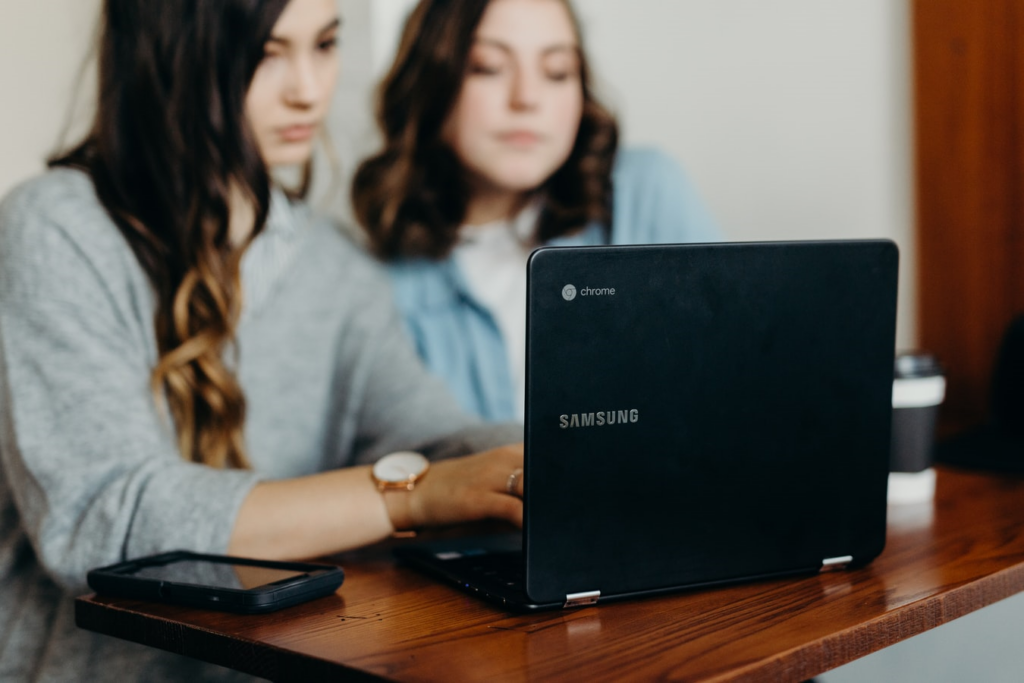 two females using a laptop