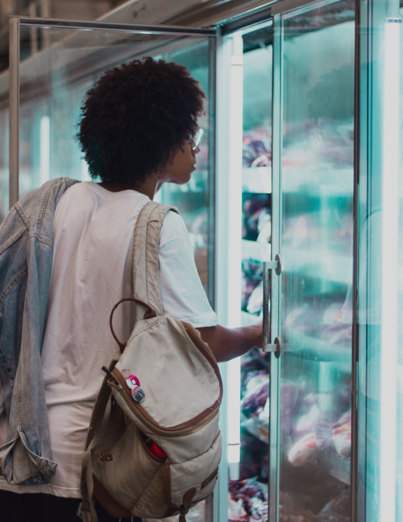 student looking in the refrigerator at the grocery store