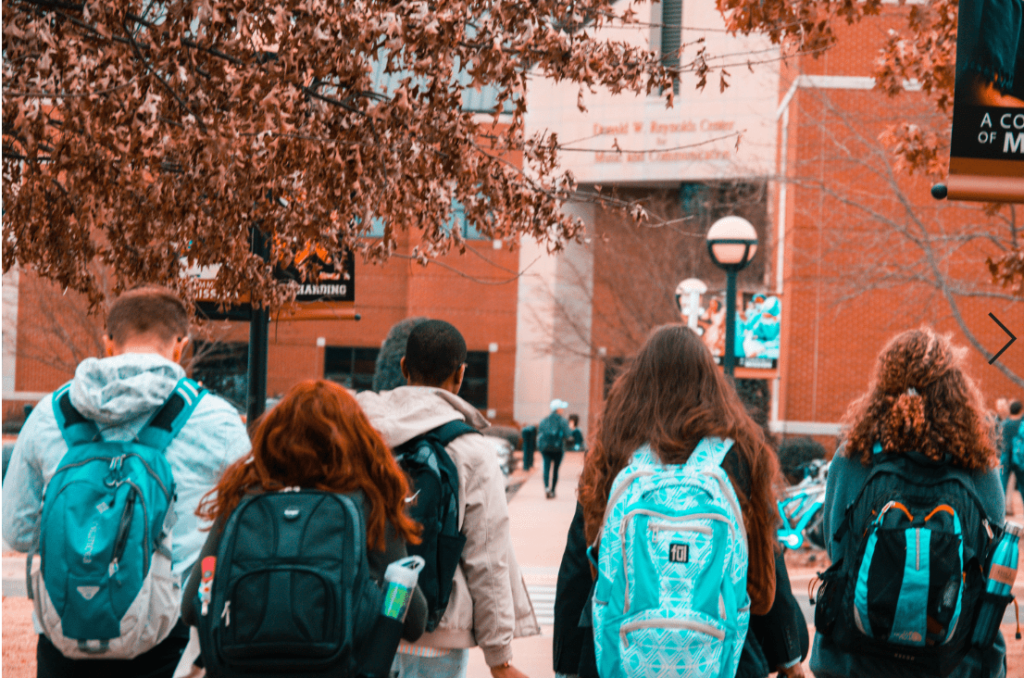 Students walking into schools with backpacks