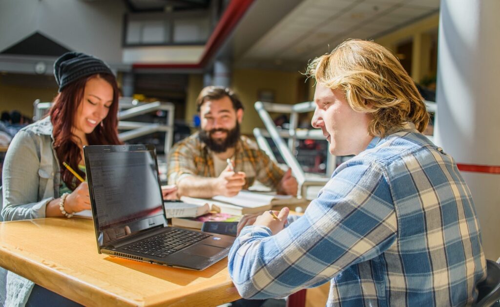 three people sitting at a table during a study session