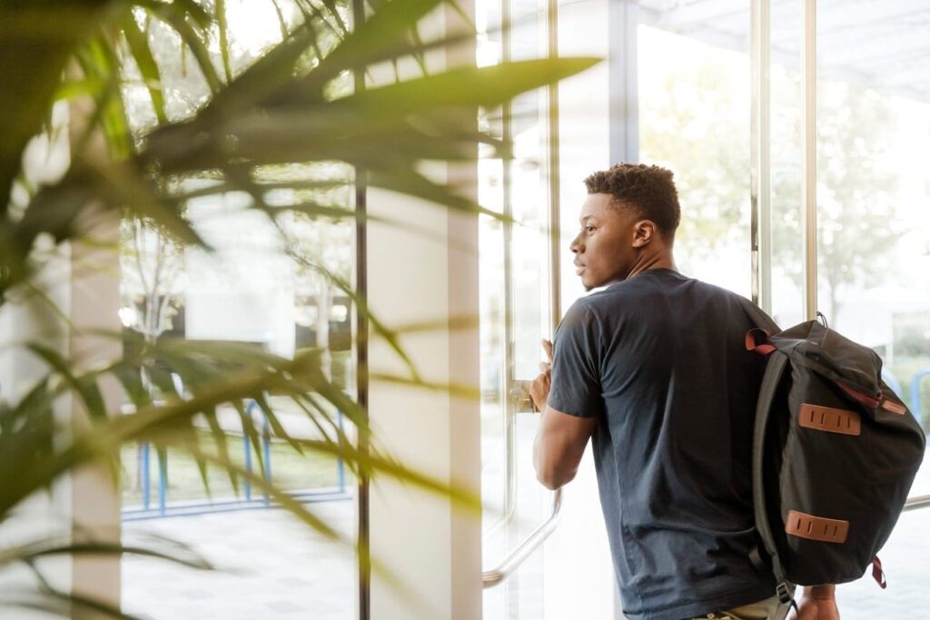 Student with backpack leaving building