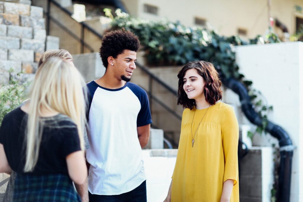 students conversing outside in front of the building