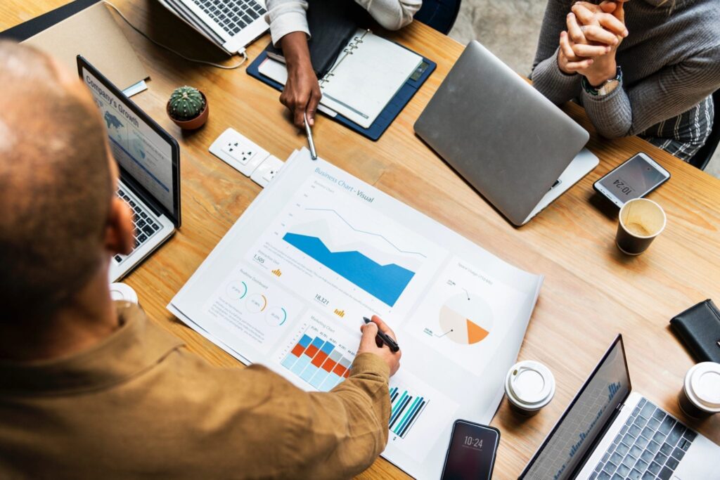 aerial view of a morning meeting analyzing charts and graphs on a table