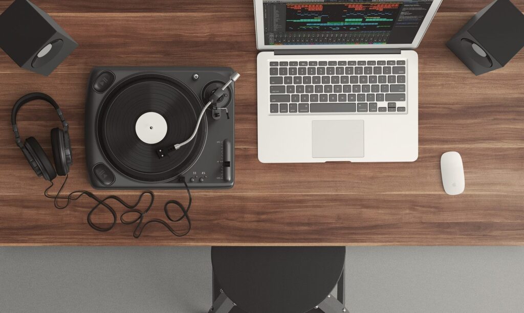 laptop set up for audio editing next to the turntable on a desk