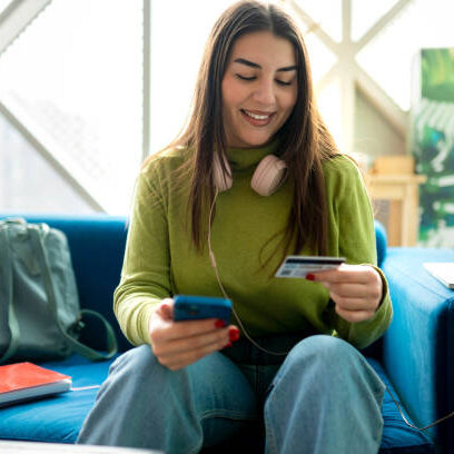 Young smiling brunette using her credit card to pay the bills