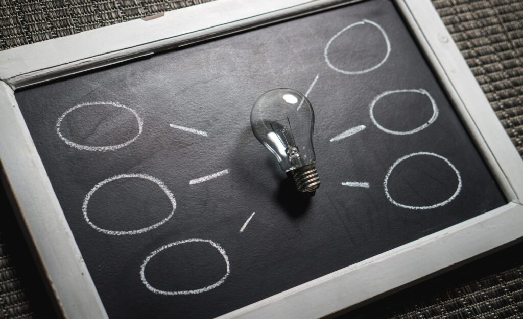 unlit lightbulb on a chalkboard