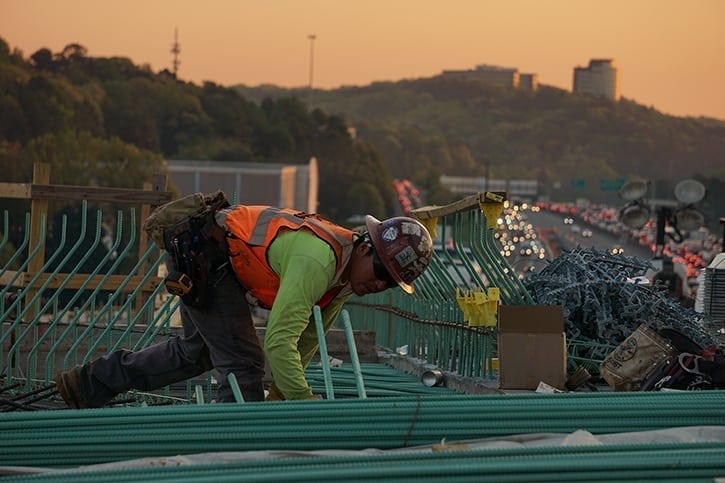 Construction Worker placing rebar for building next to a highway