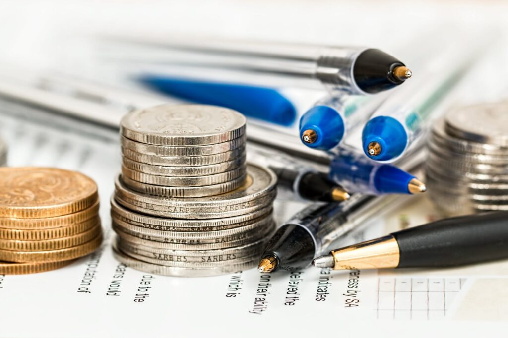 zoomed in photo of multiple pens and various stacks of coinage