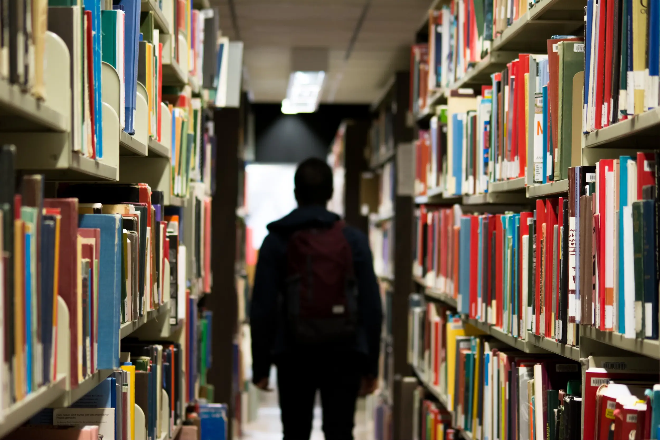 Student in library book aisle