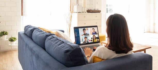 woman sitting on couch while on a zoom call