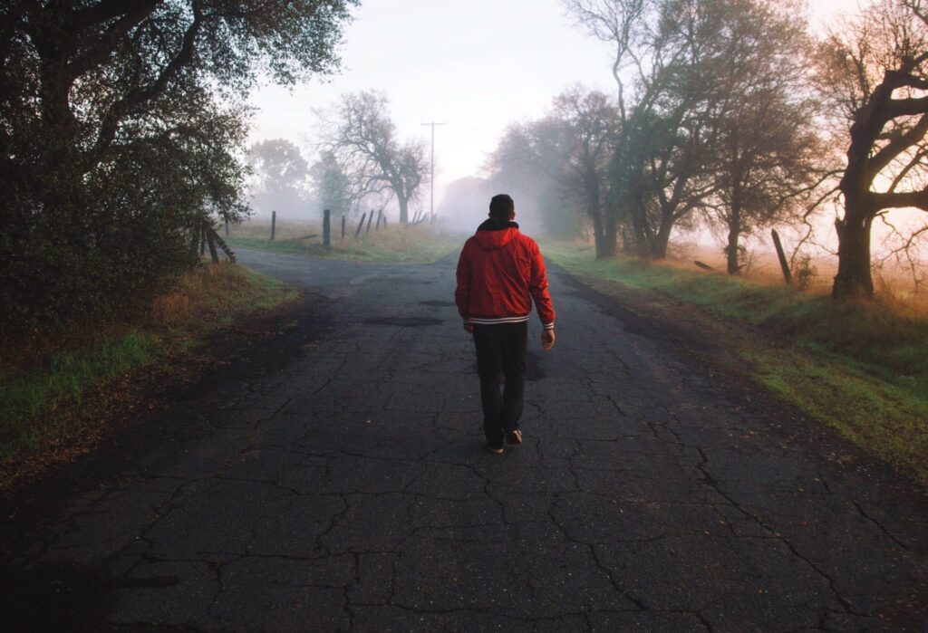 Man walking toward foggy fork in the road