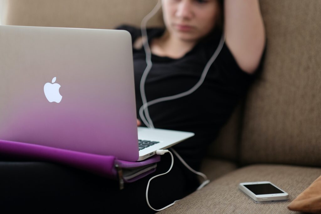 woman on a Mac laptop with headphones on