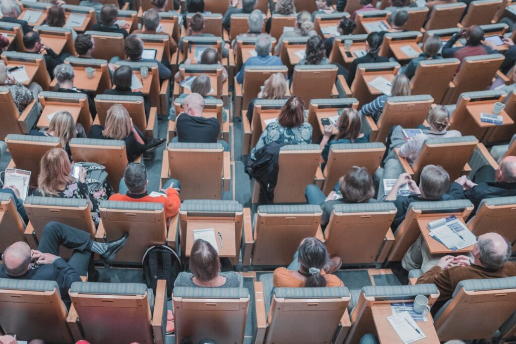 an aerial view of people listening and taking notes at a seminar