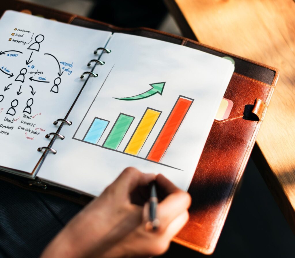 Hand drawing Bar Graph in a notebook showing upward growth