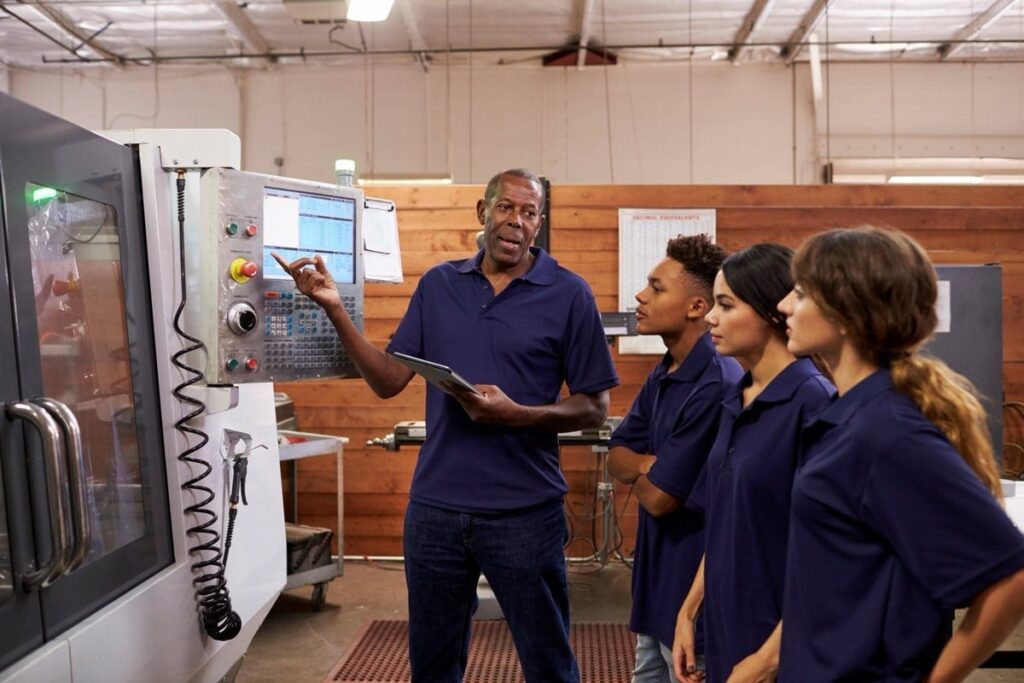 Students learning from the teacher on instruction for machine operation