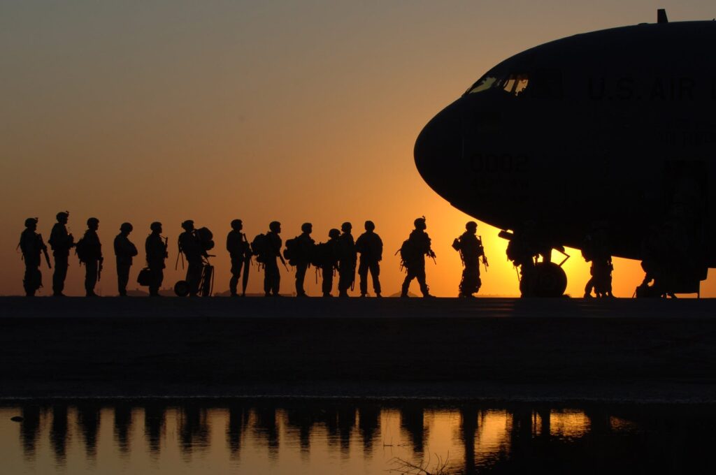 military personnel at sunset waiting to board the plane