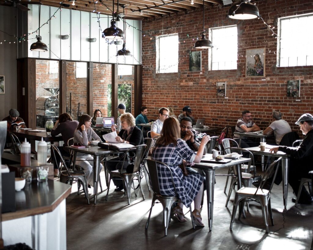 various groups of people talking and eating in a cafe